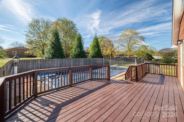 deck featuring a covered pool