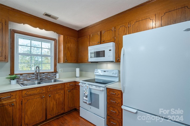 kitchen featuring a textured ceiling, dark hardwood / wood-style flooring, white appliances, and sink