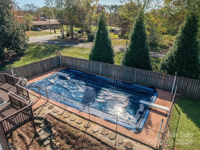 view of swimming pool with a diving board