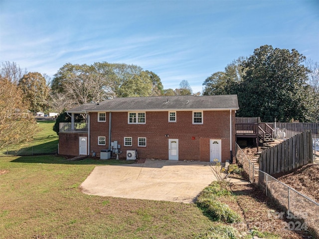 rear view of property featuring central AC, a wooden deck, a patio area, and a lawn