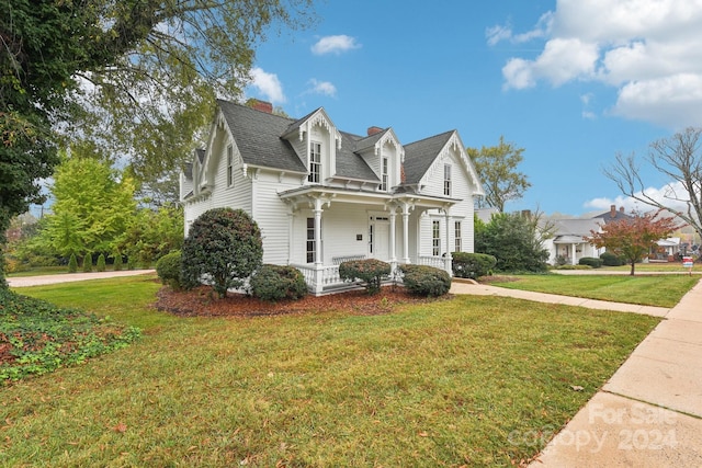 view of side of home featuring a yard and covered porch