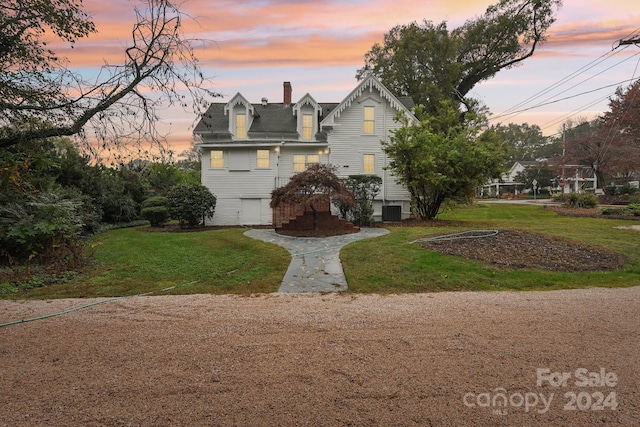 property exterior at dusk with a yard