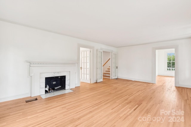 unfurnished living room featuring a premium fireplace and light wood-type flooring