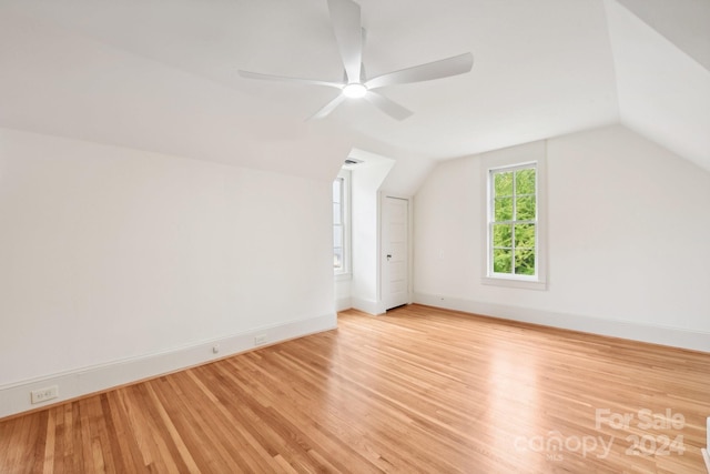 additional living space featuring ceiling fan, light hardwood / wood-style floors, and vaulted ceiling