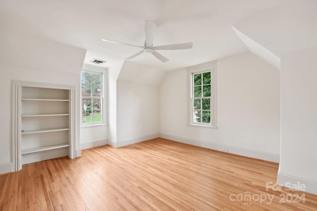 bonus room with ceiling fan, built in features, vaulted ceiling, and light wood-type flooring