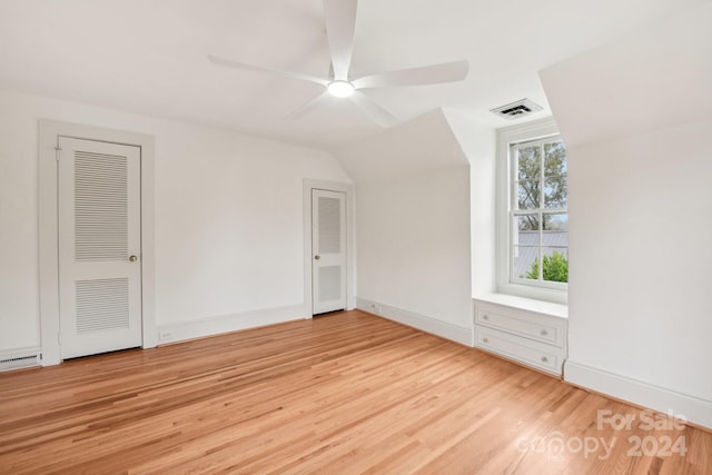 bonus room featuring a baseboard heating unit, light hardwood / wood-style flooring, ceiling fan, and lofted ceiling