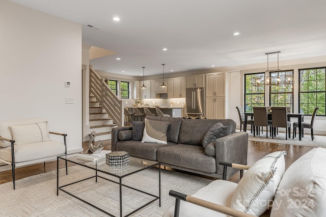 living room featuring a chandelier and light wood-type flooring