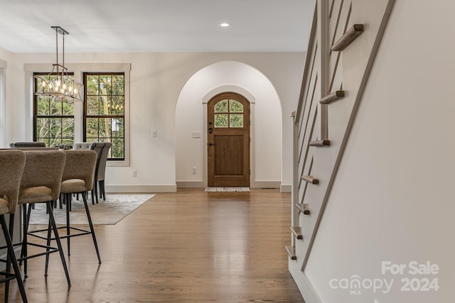 entrance foyer with wood-type flooring and an inviting chandelier