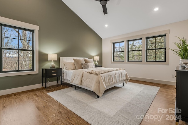 bedroom with ceiling fan, light hardwood / wood-style floors, high vaulted ceiling, and multiple windows