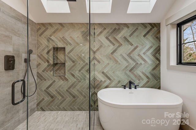 bathroom with tile walls and independent shower and bath