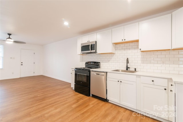 kitchen with sink, white cabinets, stainless steel appliances, and light wood-type flooring