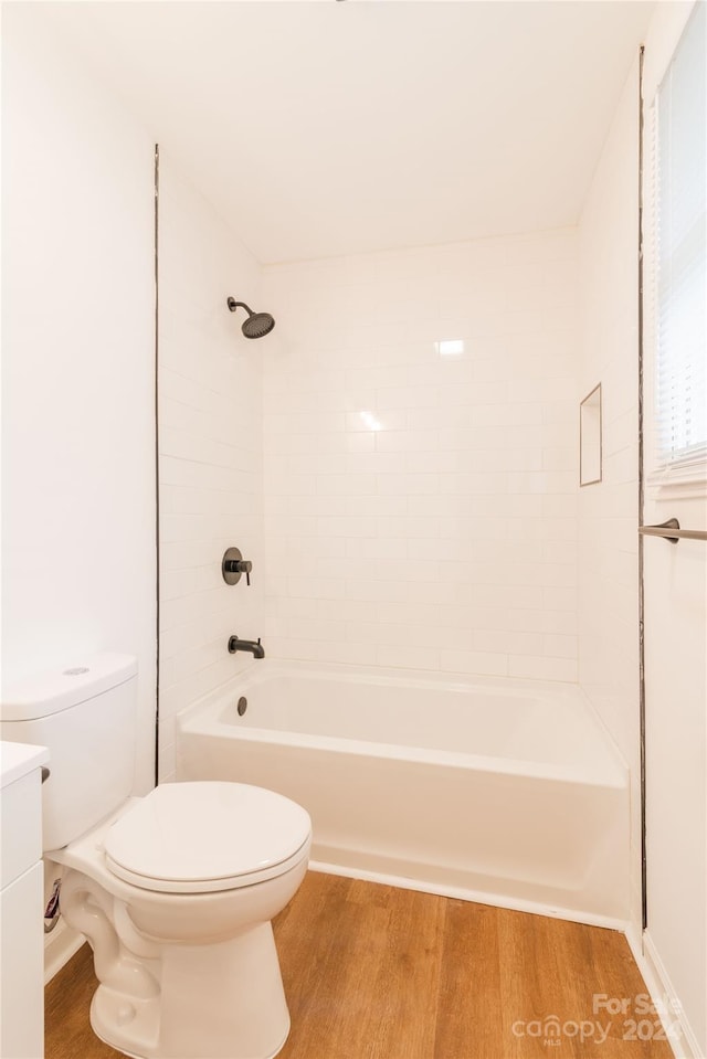 full bathroom with hardwood / wood-style floors, vanity, toilet, and tiled shower / bath