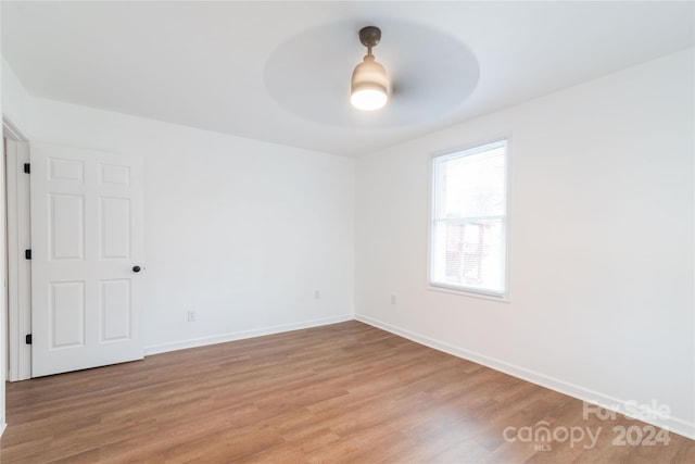 empty room with ceiling fan and light hardwood / wood-style flooring