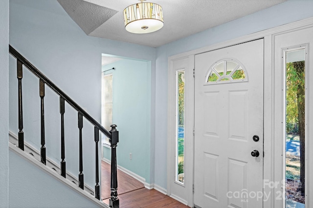 foyer with wood-type flooring and a textured ceiling