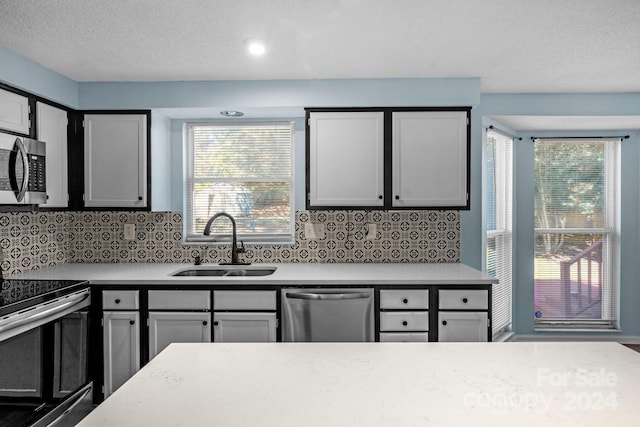 kitchen featuring appliances with stainless steel finishes, tasteful backsplash, and sink