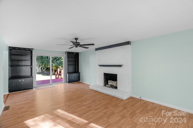 unfurnished living room featuring ceiling fan, light hardwood / wood-style floors, and a brick fireplace