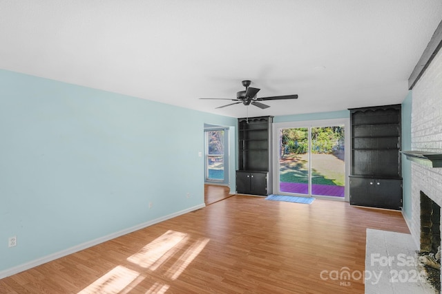 unfurnished living room featuring a fireplace, light hardwood / wood-style flooring, and ceiling fan