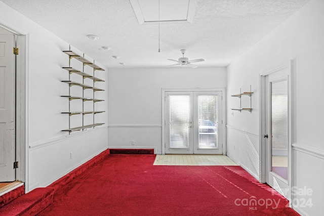 unfurnished room with ceiling fan, carpet, and a textured ceiling