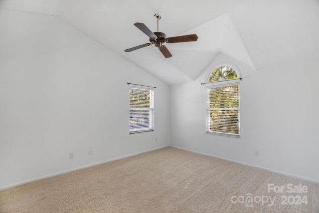 carpeted spare room featuring ceiling fan and lofted ceiling