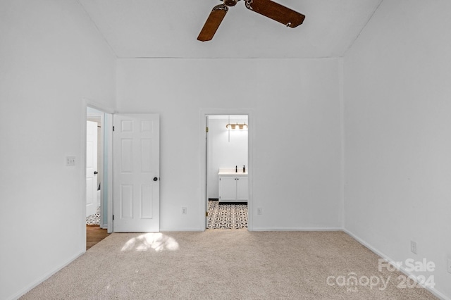 unfurnished bedroom featuring carpet flooring, ensuite bathroom, and ceiling fan