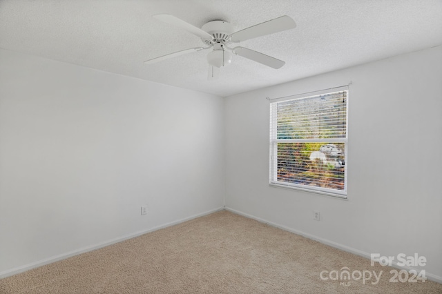 spare room with light carpet, a textured ceiling, and ceiling fan