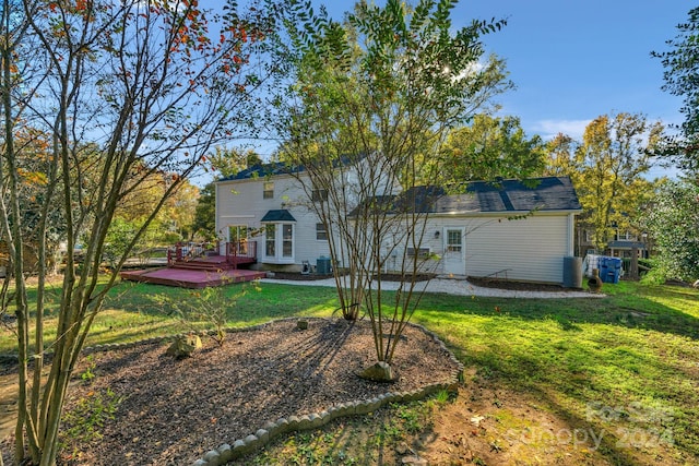 back of property featuring a yard, central air condition unit, and a wooden deck