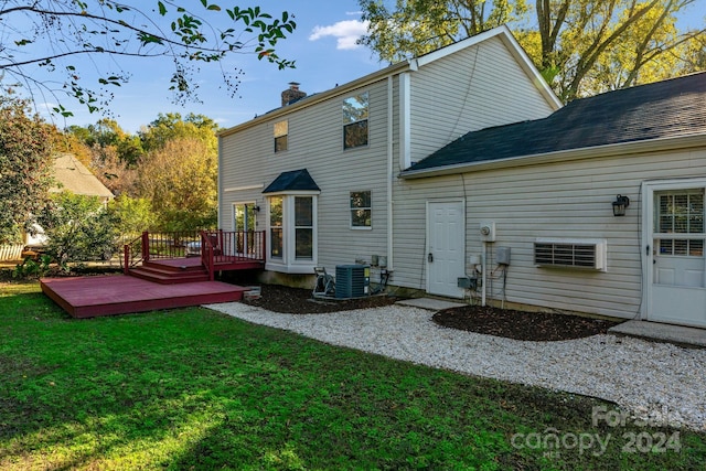 rear view of house with a lawn, central AC unit, and a wooden deck