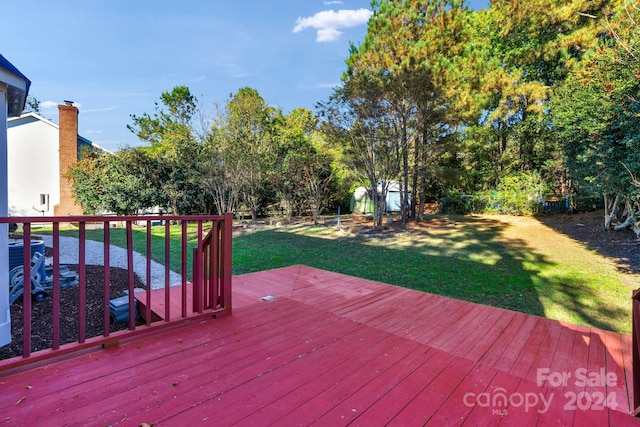 deck featuring a lawn and a shed