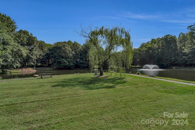 view of home's community with a yard and a water view