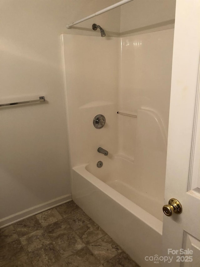 bathroom with shower / bath combination and baseboards