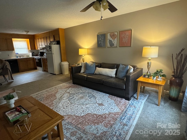 living room with a ceiling fan, light colored carpet, and a textured ceiling