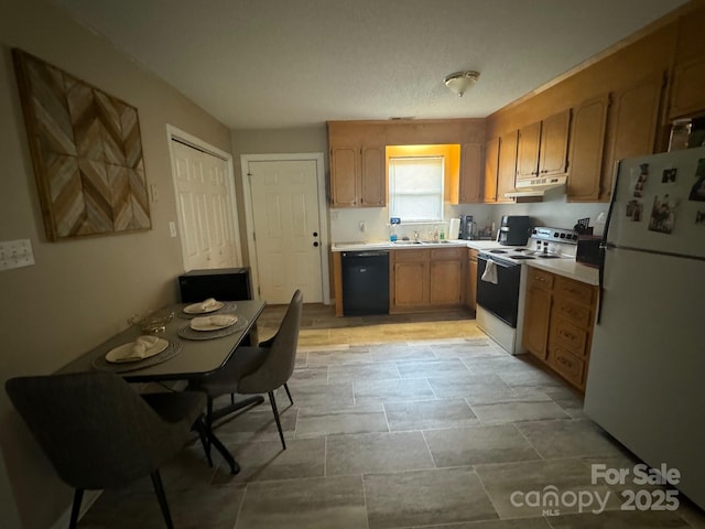 kitchen featuring white appliances, brown cabinetry, light countertops, under cabinet range hood, and a sink