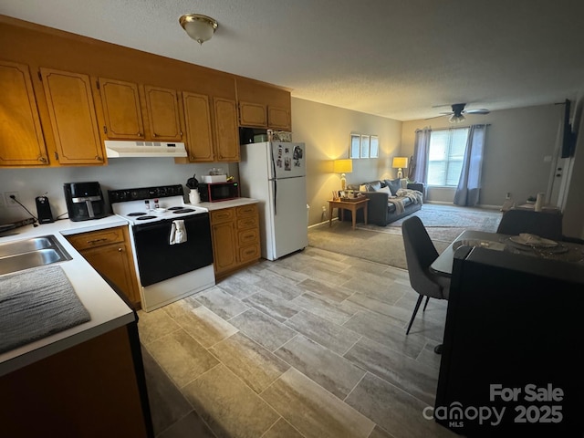 kitchen featuring electric stove, light countertops, freestanding refrigerator, open floor plan, and under cabinet range hood