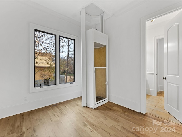 unfurnished bedroom with multiple windows, crown molding, and light hardwood / wood-style flooring