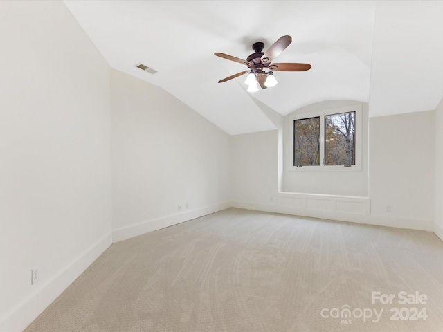 additional living space featuring ceiling fan, light colored carpet, and lofted ceiling