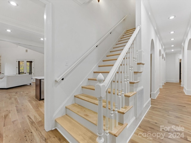 stairway featuring hardwood / wood-style floors, french doors, and lofted ceiling