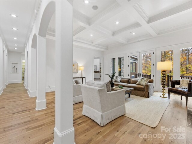 living room featuring decorative columns, coffered ceiling, beam ceiling, and light hardwood / wood-style floors