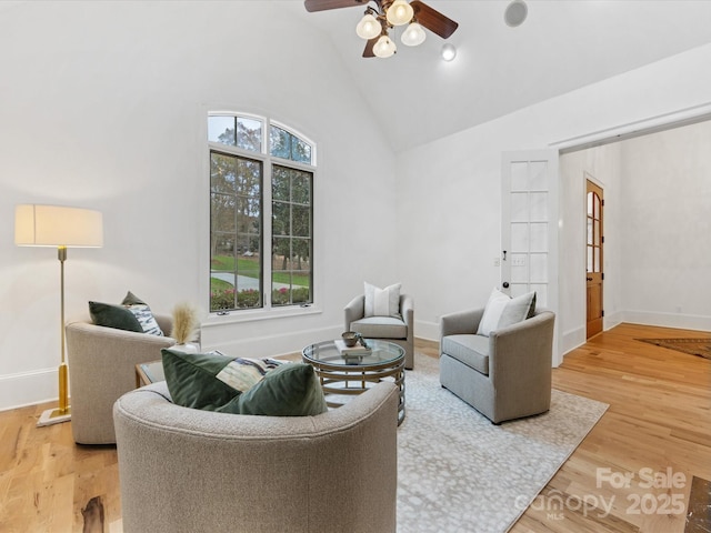 living room featuring hardwood / wood-style flooring, high vaulted ceiling, and ceiling fan