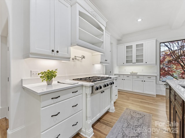 kitchen with white cabinetry, appliances with stainless steel finishes, ornamental molding, and light hardwood / wood-style flooring