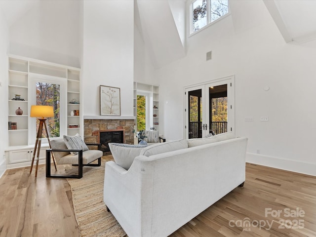 living room with a healthy amount of sunlight, a fireplace, and light hardwood / wood-style flooring