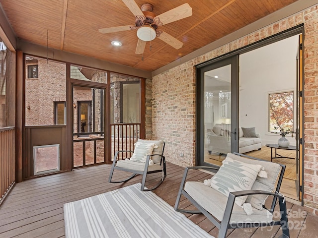 sunroom featuring ceiling fan and wooden ceiling