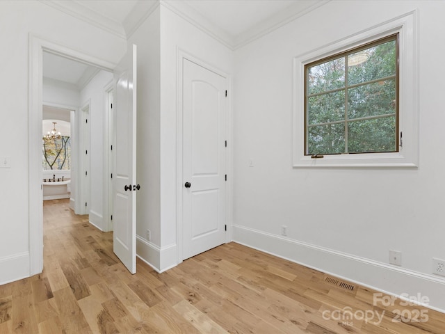 interior space featuring ornamental molding, a notable chandelier, and light hardwood / wood-style flooring