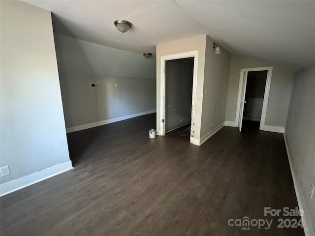 additional living space featuring dark hardwood / wood-style floors and lofted ceiling