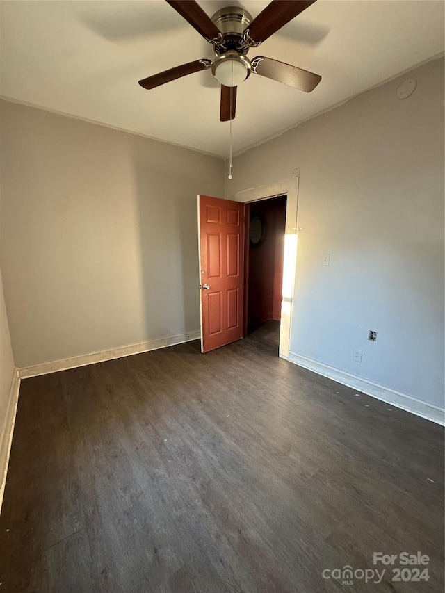 unfurnished bedroom with ceiling fan and dark wood-type flooring