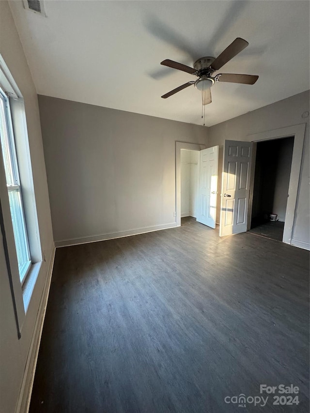 unfurnished bedroom featuring ceiling fan and dark hardwood / wood-style flooring