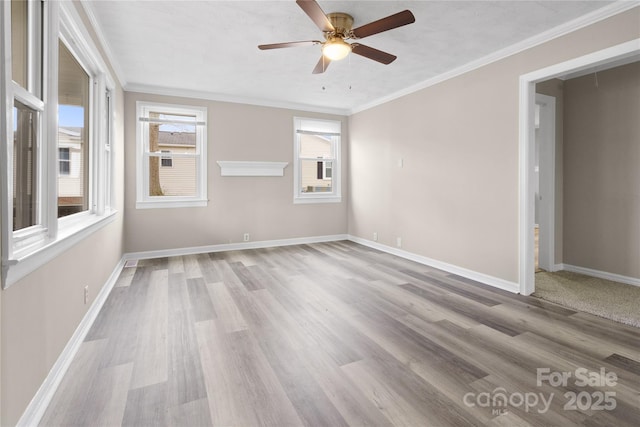 unfurnished room with ornamental molding, wood finished floors, a ceiling fan, and baseboards