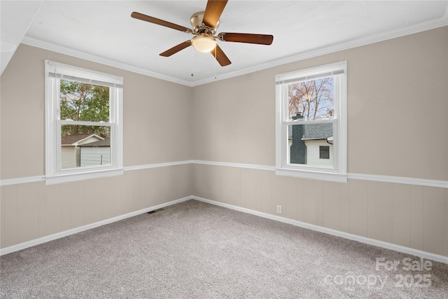 unfurnished room with carpet floors, a healthy amount of sunlight, crown molding, and visible vents