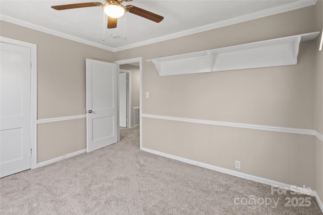 spare room featuring ceiling fan, ornamental molding, carpet, and visible vents