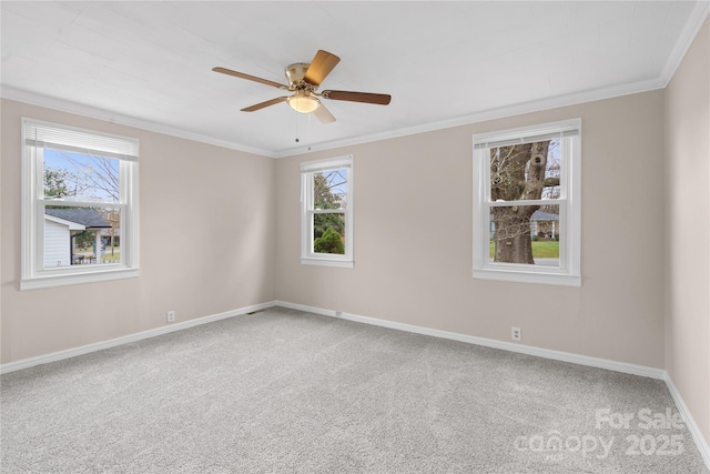 empty room featuring ceiling fan, baseboards, crown molding, and carpet flooring