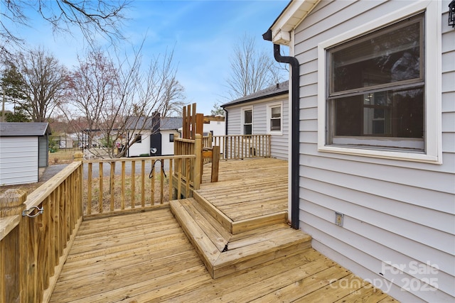 wooden terrace featuring an outbuilding and a storage unit